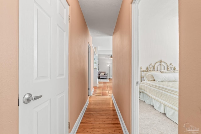 corridor with light hardwood / wood-style flooring