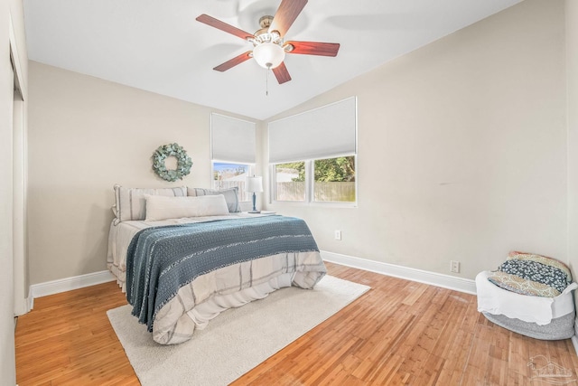 bedroom with ceiling fan, lofted ceiling, and light hardwood / wood-style floors