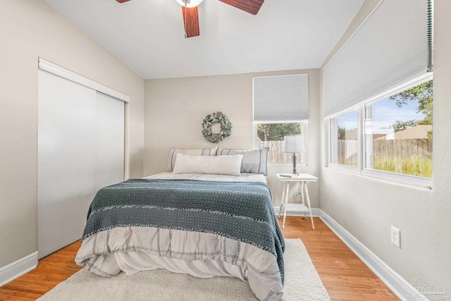 bedroom with hardwood / wood-style flooring, ceiling fan, and a closet