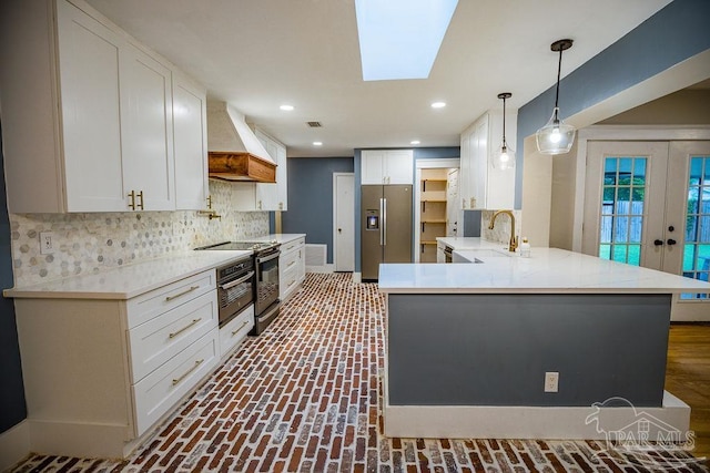 kitchen featuring stainless steel appliances, white cabinets, pendant lighting, and custom exhaust hood