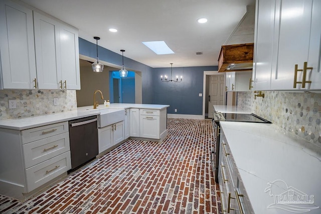 kitchen featuring sink, a skylight, white cabinetry, appliances with stainless steel finishes, and decorative light fixtures