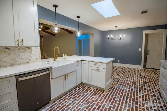 kitchen with sink, kitchen peninsula, a skylight, stainless steel dishwasher, and pendant lighting