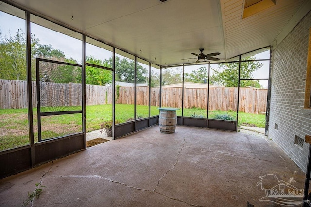 unfurnished sunroom featuring ceiling fan and a healthy amount of sunlight