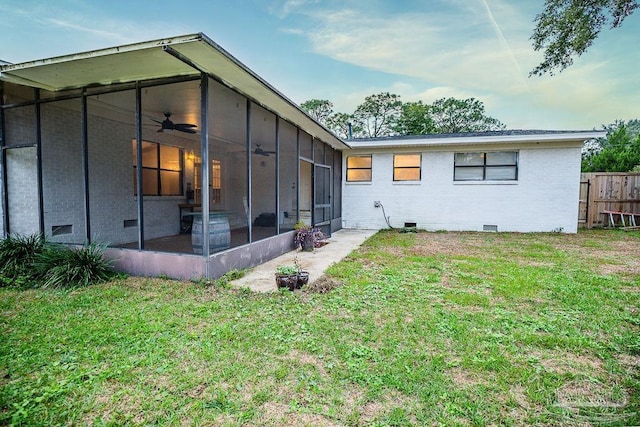 back of property with a sunroom and a yard