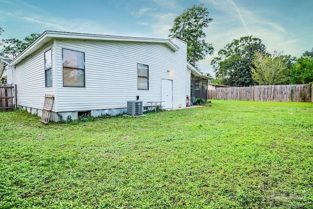 view of home's exterior with cooling unit and a lawn