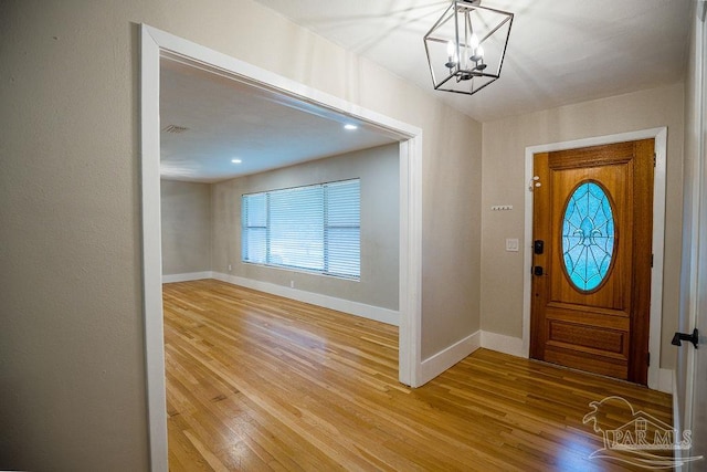 foyer entrance featuring an inviting chandelier and hardwood / wood-style floors