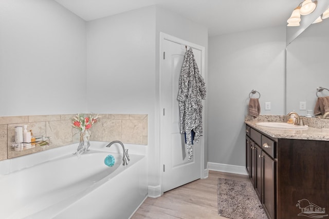6743 Desoto St, Navarre, FL 32566 - full bath featuring vanity, a bath, wood finished floors, and baseboards