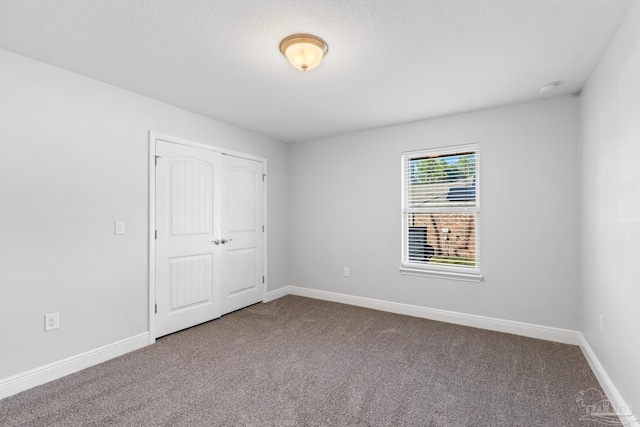 6743 Desoto St, Navarre, FL 32566 - unfurnished bedroom with dark colored carpet, baseboards, and a closet