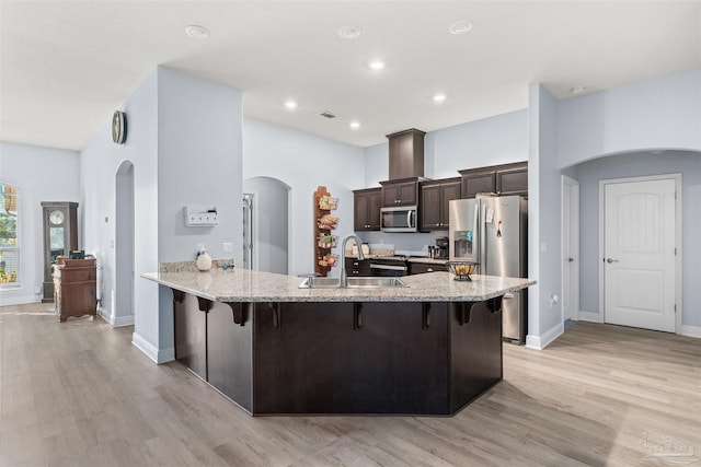 6743 Desoto St, Navarre, FL 32566 - kitchen featuring appliances with stainless steel finishes, a sink, arched walkways, a kitchen bar, and dark brown cabinetry