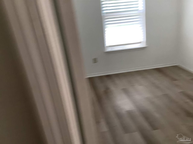 empty room featuring baseboards and wood finished floors