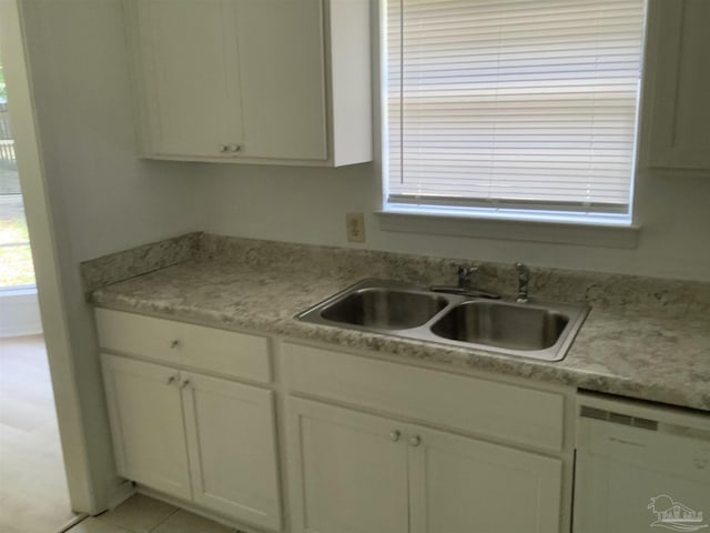 kitchen featuring white cabinets, dishwasher, light countertops, and a sink