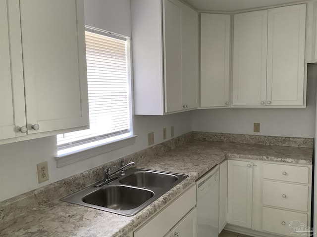 kitchen with dishwasher, white cabinetry, light countertops, and a sink