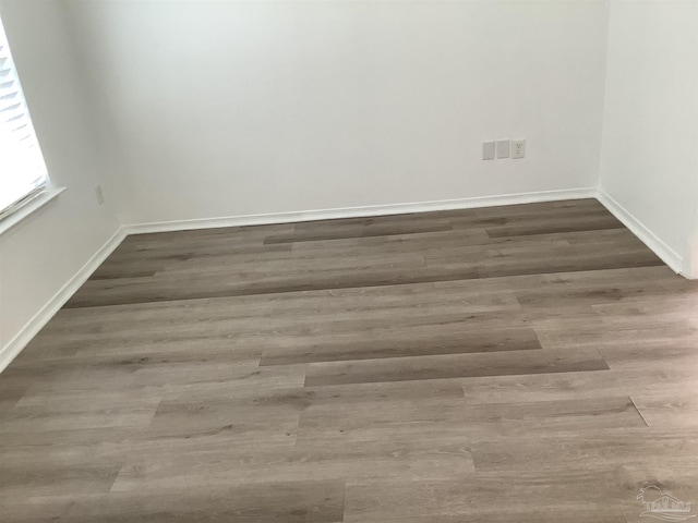 empty room with baseboards and wood finished floors