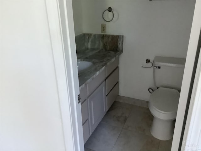 bathroom with toilet, tile patterned flooring, and vanity