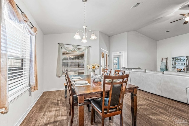 dining area with ceiling fan with notable chandelier, lofted ceiling, and hardwood / wood-style flooring