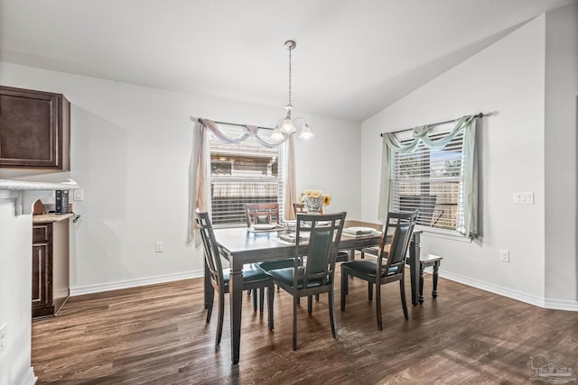 dining area with dark hardwood / wood-style floors, lofted ceiling, and a notable chandelier