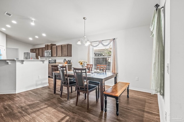 dining space with dark wood-type flooring, vaulted ceiling, and an inviting chandelier