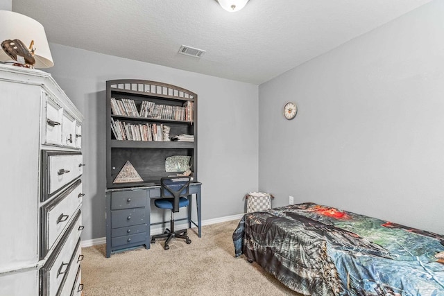 bedroom with light carpet and a textured ceiling