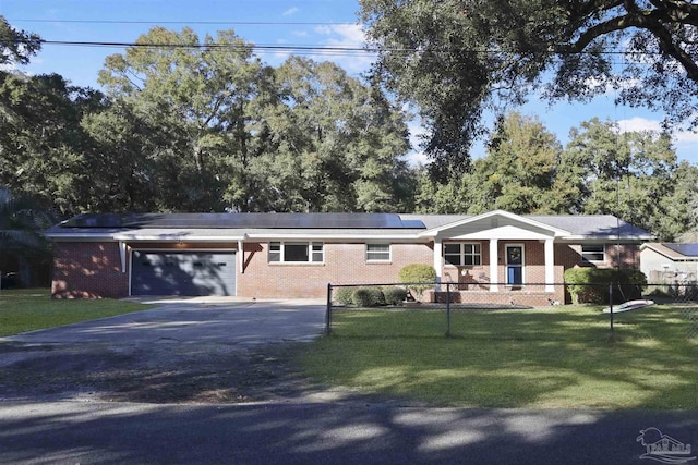 ranch-style house with a garage, a front lawn, and solar panels