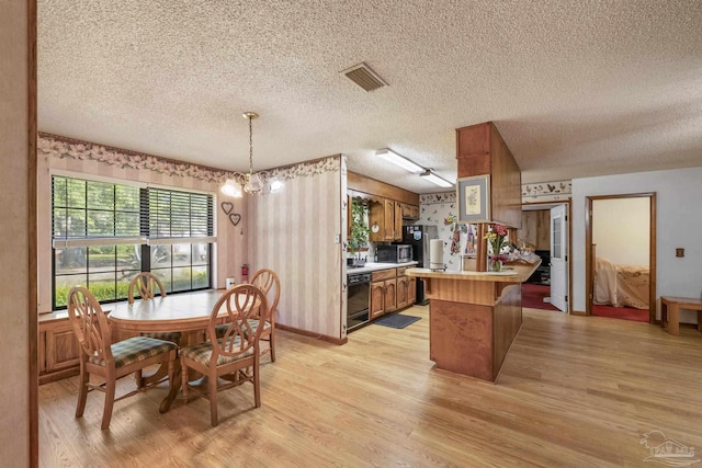 dining space with a textured ceiling and light wood-type flooring