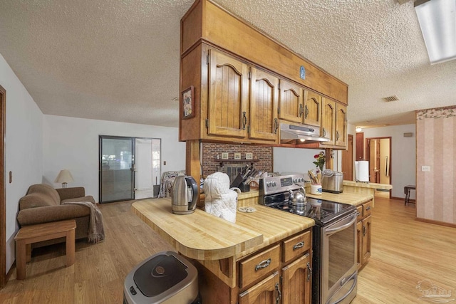 kitchen featuring a textured ceiling, light wood-style flooring, under cabinet range hood, and stainless steel electric range