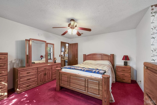 bedroom with ceiling fan, dark carpet, and a textured ceiling