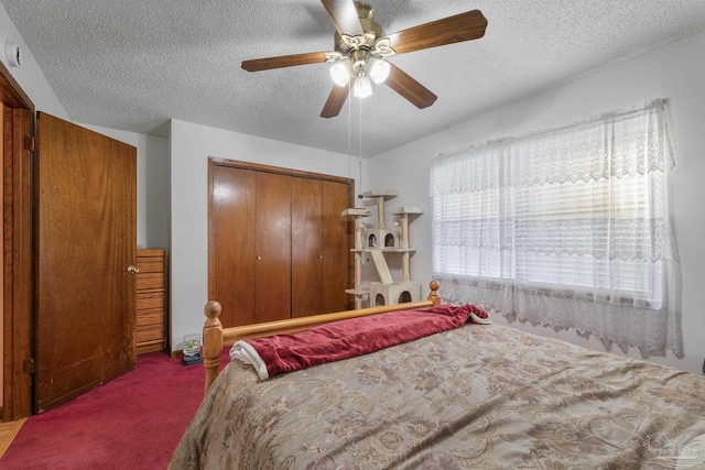 carpeted bedroom with a closet, a ceiling fan, and a textured ceiling
