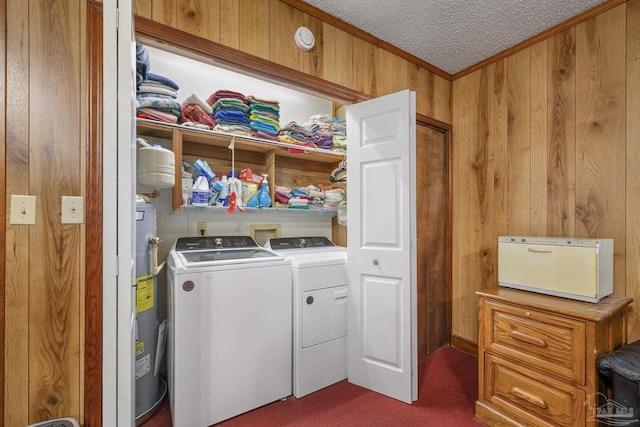 laundry area featuring laundry area, wood walls, dark carpet, electric water heater, and separate washer and dryer