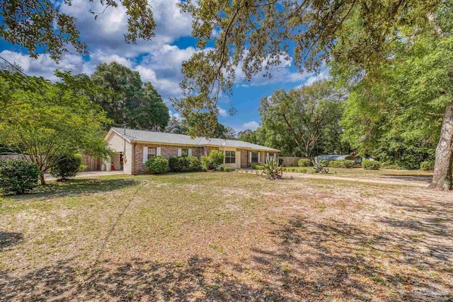 view of front of house featuring fence, a front lawn, and brick siding
