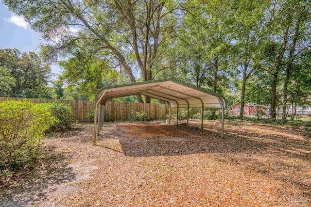 view of car parking with fence and a carport