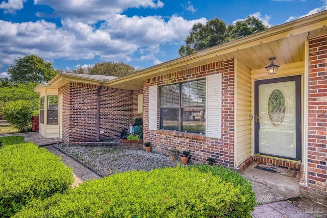 entrance to property featuring brick siding