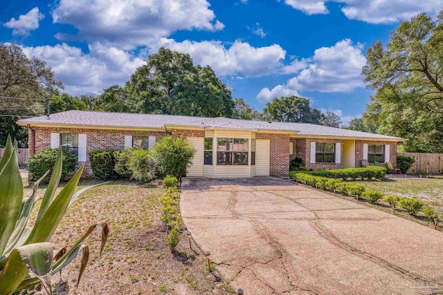 single story home featuring fence, driveway, and brick siding