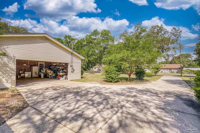 view of side of home featuring concrete driveway and a garage