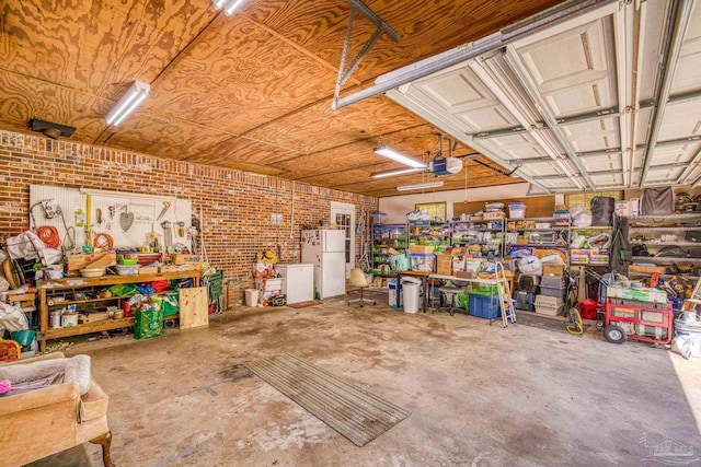 garage featuring freestanding refrigerator, a garage door opener, and a workshop area