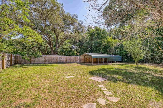 view of yard featuring a fenced backyard and a carport