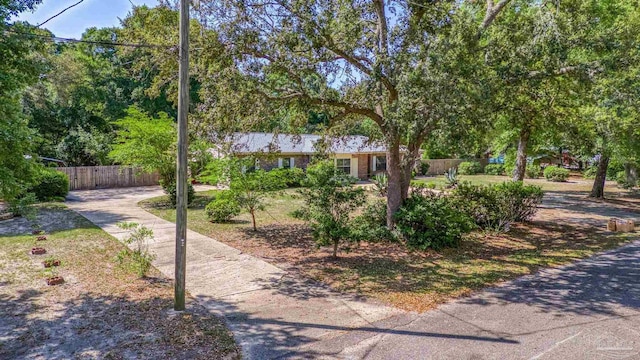 view of property hidden behind natural elements featuring fence