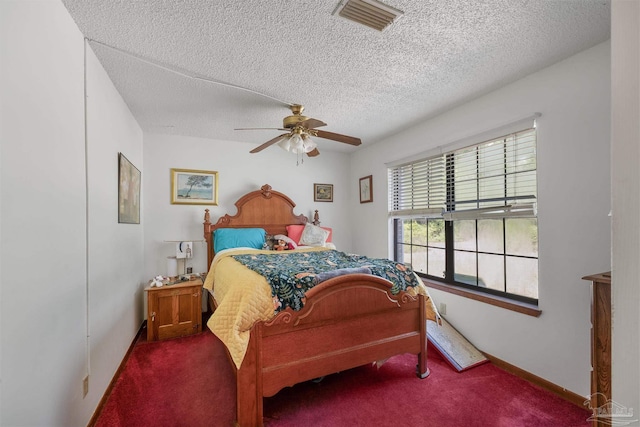 carpeted bedroom with visible vents, a ceiling fan, and a textured ceiling