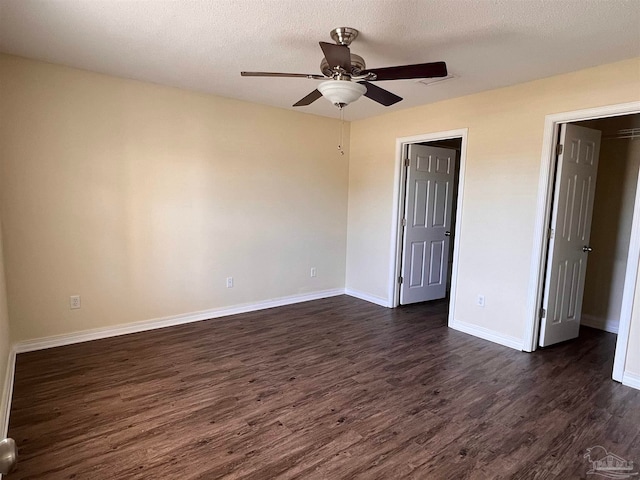 interior space featuring a textured ceiling, ceiling fan, and dark hardwood / wood-style floors