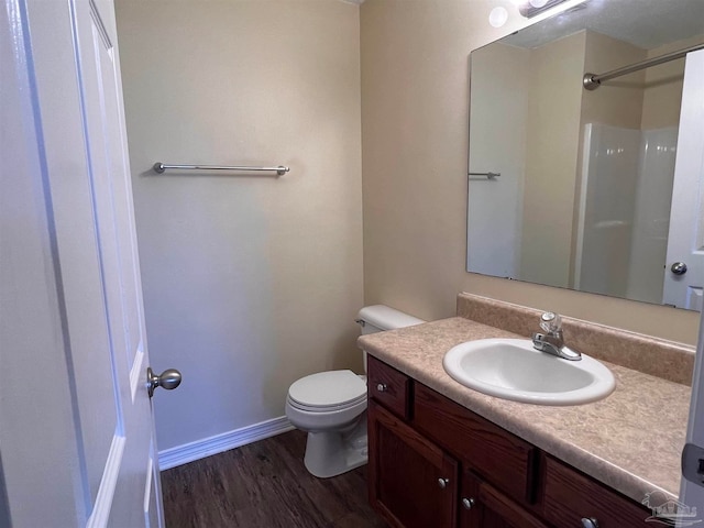 bathroom with a shower, wood-type flooring, toilet, and vanity