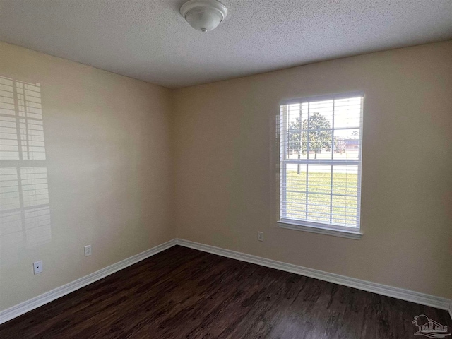 unfurnished room featuring a textured ceiling and dark hardwood / wood-style flooring