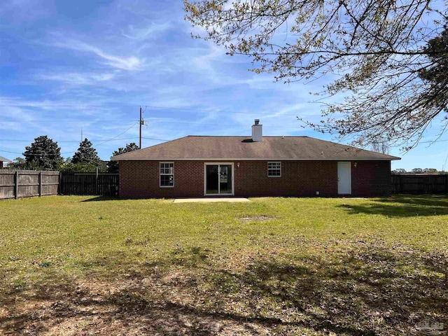 rear view of property featuring a lawn and a patio area