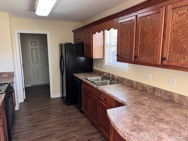 kitchen with a textured ceiling, black appliances, sink, and dark hardwood / wood-style floors