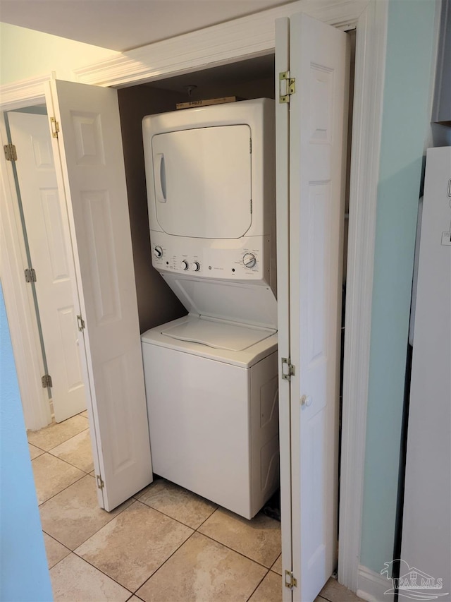 laundry room with laundry area, stacked washing maching and dryer, and light tile patterned flooring