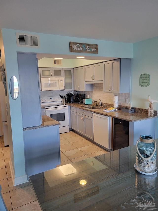 kitchen featuring white appliances, visible vents, a sink, and light tile patterned flooring