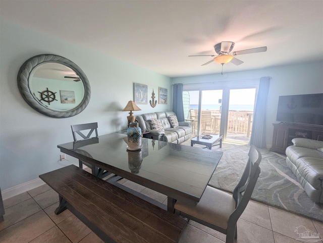 dining area featuring light tile patterned floors, a ceiling fan, and baseboards