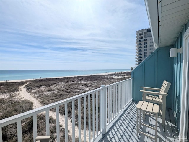 balcony featuring a water view and a beach view