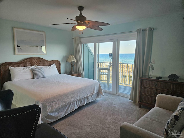 carpeted bedroom with ceiling fan, a water view, and access to exterior