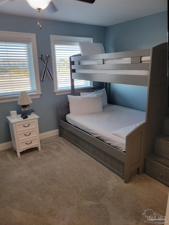 carpeted bedroom with baseboards and a ceiling fan