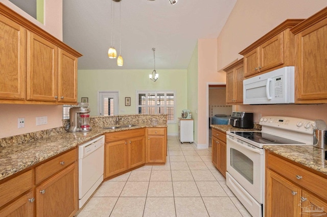 kitchen with white appliances, brown cabinets, and a sink