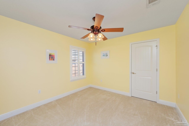 unfurnished room featuring light carpet, a ceiling fan, visible vents, and baseboards